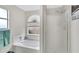 Bright bathroom with soaking tub under arched window and glass shower enclosure at 4329 W Electra Ln, Glendale, AZ 85310