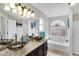 Bathroom with dual vessel sinks, granite counters, soaking tub and arched window at 4329 W Electra Ln, Glendale, AZ 85310