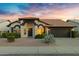 Home exterior featuring desert landscaping and two-car garage at 4329 W Electra Ln, Glendale, AZ 85310