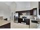 Modern kitchen with stainless steel appliances, dark cabinetry, and tile backsplash at 4329 W Electra Ln, Glendale, AZ 85310