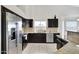 Modern kitchen featuring stainless appliances, granite counters, and dark wood cabinets at 4329 W Electra Ln, Glendale, AZ 85310