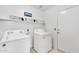 Bright laundry room featuring a washer, dryer, and white shelving at 4329 W Electra Ln, Glendale, AZ 85310