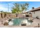 Backyard swimming pool with rock waterfall feature, desert landscaping, and basketball hoop at 4329 W Electra Ln, Glendale, AZ 85310