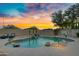 Stunning pool area with a rock waterfall feature, lush palm trees, and comfortable lounge chairs at 4329 W Electra Ln, Glendale, AZ 85310