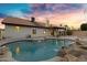 Backyard pool with waterfall and desert landscaping at 4329 W Electra Ln, Glendale, AZ 85310