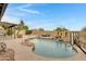 Backyard features a pool with waterfall, basketball hoop, covered patio, and desert landscaping at 4329 W Electra Ln, Glendale, AZ 85310