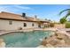 Backyard pool with waterfall, rock features, and desert landscaping at 4329 W Electra Ln, Glendale, AZ 85310