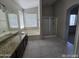 Bright bathroom featuring dual sinks, soaking tub, glass shower, and neutral finishes at 43455 W Chisholm Dr, Maricopa, AZ 85138