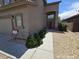 Exterior side view of a home showcasing desert landscaping and arched entryway at 43455 W Chisholm Dr, Maricopa, AZ 85138