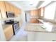 Well-equipped kitchen with stainless steel appliances, granite countertops, and light wood cabinetry at 43455 W Chisholm Dr, Maricopa, AZ 85138