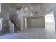 Spacious living area featuring high ceilings, tile flooring, and a grand staircase to the second floor at 43455 W Chisholm Dr, Maricopa, AZ 85138