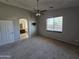 Large main bedroom with a ceiling fan, neutral paint, and an en-suite bathroom view from the doorway at 43455 W Chisholm Dr, Maricopa, AZ 85138