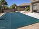 Backyard pool is covered next to desert landscaping with palm trees in the background at 43455 W Chisholm Dr, Maricopa, AZ 85138
