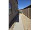 Narrow side yard featuring a concrete walkway and gravel landscaping for low maintenance at 43455 W Chisholm Dr, Maricopa, AZ 85138