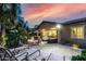 Spacious backyard featuring a fire pit, comfortable seating, and mature palm trees against a colorful sunset at 4519 N 29Th Way, Phoenix, AZ 85016