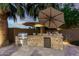 Outdoor kitchen with built-in grill, stone counter, beverage cooler, and lush landscaping in the backyard at 4519 N 29Th Way, Phoenix, AZ 85016