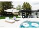 Stylish backyard features a covered outdoor living area, pool, and lounge chairs, perfect for relaxing and entertaining at 5 E Oakwood Hills Dr, Chandler, AZ 85248