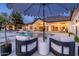 Relaxing backyard featuring a pool, lounge chairs, and umbrella with an outdoor bar and home in the background at 5 E Oakwood Hills Dr, Chandler, AZ 85248