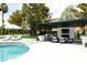 Backyard featuring a covered outdoor living space, a built-in grill, a pool, and lush landscaping, ideal for entertaining at 5 E Oakwood Hills Dr, Chandler, AZ 85248