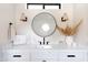 Stylish bathroom vanity featuring a round mirror, chic sconces, and elegant décor, creating a spa-like retreat at 5 E Oakwood Hills Dr, Chandler, AZ 85248