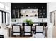 Modern dining area with a wooden table, upholstered chairs, and a stylish bar area with black cabinets at 5 E Oakwood Hills Dr, Chandler, AZ 85248