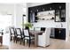 Modern dining room with stylish chairs, wood table, black cabinets, and ample natural light at 5 E Oakwood Hills Dr, Chandler, AZ 85248