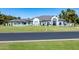 Expansive property with lush lawn, mature trees, and a well-maintained white home featuring a grand arched entrance at 5 E Oakwood Hills Dr, Chandler, AZ 85248