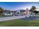 Elegant home exterior showcasing circular driveway, manicured lawn, and a grand arched entryway illuminated at twilight at 5 E Oakwood Hills Dr, Chandler, AZ 85248