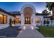 Close up view of a home's front entrance featuring an arched entryway, illuminated steps, and detailed landscaping at 5 E Oakwood Hills Dr, Chandler, AZ 85248