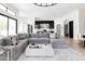 Spacious living room with a large sectional sofa, light wood floors, and views of the modern kitchen at 5 E Oakwood Hills Dr, Chandler, AZ 85248