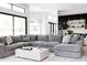 Open living space with a cozy sectional sofa, large windows, and a view into the modern kitchen at 5 E Oakwood Hills Dr, Chandler, AZ 85248