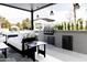 Inviting outdoor living area with a built-in grill, ample seating, and a view of the lush backyard at 5 E Oakwood Hills Dr, Chandler, AZ 85248
