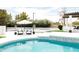 Stylish outdoor patio with elegant seating, an umbrella, a beautiful pool, and lush landscaping for a perfect outdoor experience at 5 E Oakwood Hills Dr, Chandler, AZ 85248