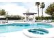 Resort-style pool area with jacuzzi, pergola, lounge chairs, and a pristine pool under a bright sky at 5 E Oakwood Hills Dr, Chandler, AZ 85248
