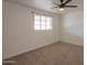 Bedroom features a ceiling fan and a bright window, complementing the neutral carpeting at 512 N Ironwood --, Mesa, AZ 85201