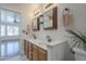 Dual sink vanity in bathroom with framed mirrors and open concept to main bedroom at 533 N Cobblestone St, Gilbert, AZ 85234