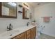 Bathroom with dual sinks, framed mirrors, sconce lighting, and neutral colors at 533 N Cobblestone St, Gilbert, AZ 85234
