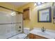 Bathroom features a shower over tub with glass door, vanity, and medicine cabinet at 533 N Cobblestone St, Gilbert, AZ 85234
