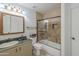 Bathroom featuring a glass-enclosed shower and tub, vanity, tile backsplash and toilet at 533 N Cobblestone St, Gilbert, AZ 85234