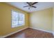 Bright bedroom features a ceiling fan, wood flooring, and a large window letting in natural light at 533 N Cobblestone St, Gilbert, AZ 85234