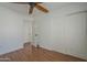 Bedroom features a ceiling fan, wood floors, closet and entrance to another area at 533 N Cobblestone St, Gilbert, AZ 85234