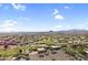 Expansive aerial view of a desert community with golf course, mountains, and single-Gathering homes at 6145 E Snowdon St, Mesa, AZ 85215