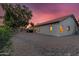 Home's backyard with desert landscaping, rock, mature tree, and covered patio at 6145 E Snowdon St, Mesa, AZ 85215