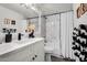 Updated bathroom with a marble-tiled shower/tub, white vanity, and black fixtures at 6145 E Snowdon St, Mesa, AZ 85215