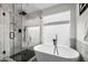 Modern bathroom with a soaking tub, glass shower, and black fixtures at 6145 E Snowdon St, Mesa, AZ 85215