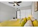 Cozy bedroom with yellow accents and a ceiling fan for comfortable climate control at 6145 E Snowdon St, Mesa, AZ 85215