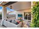 Comfortable covered patio with lounge seating, a television, and access to the home's interior at 6145 E Snowdon St, Mesa, AZ 85215