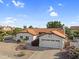A charming single-story home showcases a red tile roof, meticulously landscaped front yard, and attached two-car garage at 6145 E Snowdon St, Mesa, AZ 85215