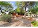 View of community building amid desert landscaping, mature trees, and inviting walkways at 6145 E Snowdon St, Mesa, AZ 85215