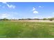 Green, grassy field with exercise bars and views of the desert landscape in the distance at 6145 E Snowdon St, Mesa, AZ 85215